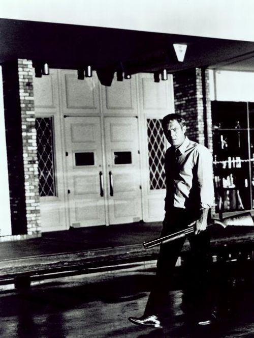 Steve McQueen (as Doc McCoy) with shotgun.